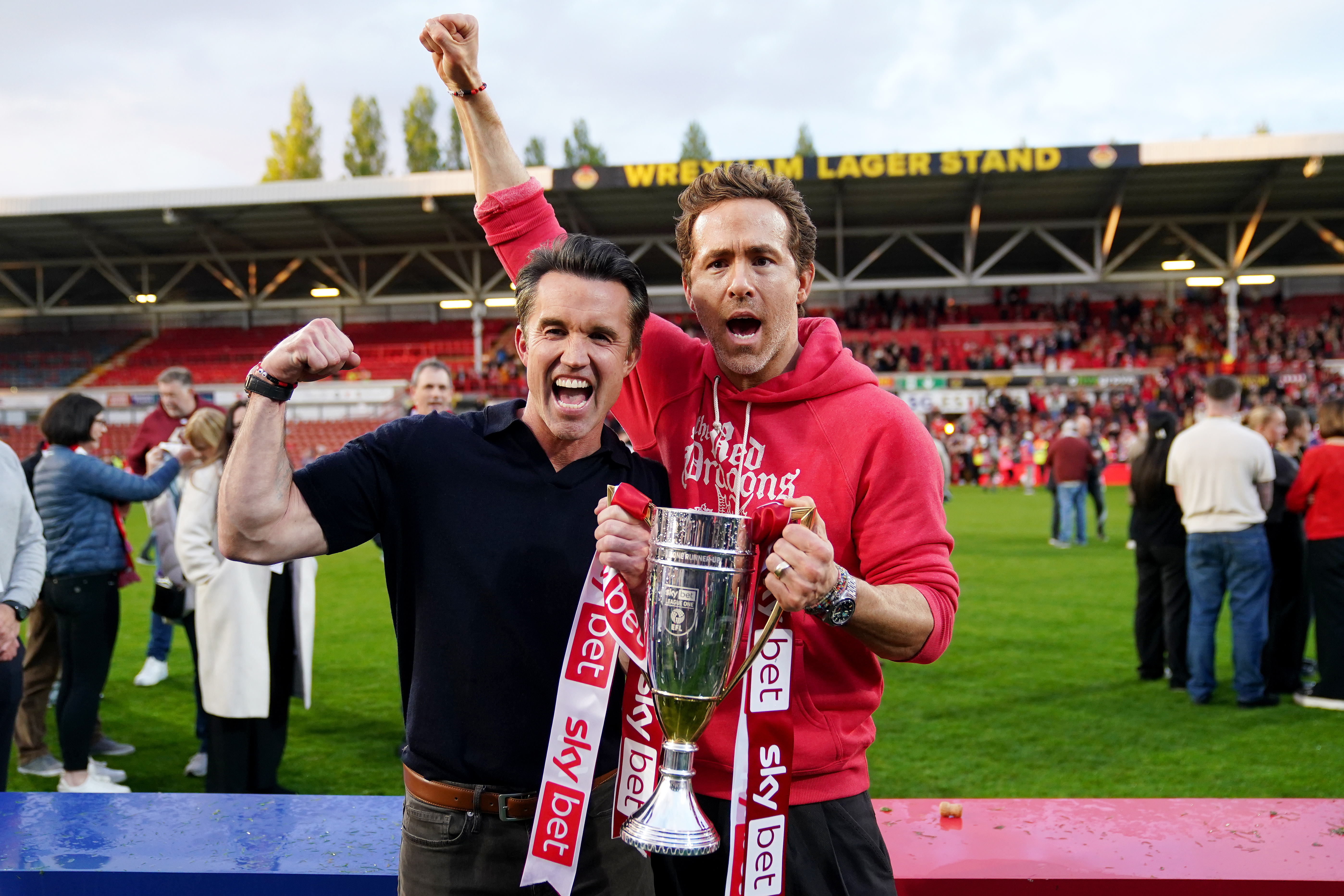 Wrexham co-owners Ryan Reynolds (right) and Rob McElhenney celebrate with the trophy after the Sky Bet League One match at SToK Racecourse, Wrexham
